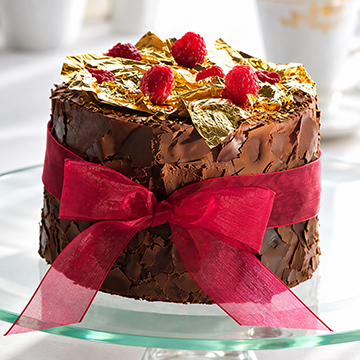 Chocolate cake dusted with gold and raspberries