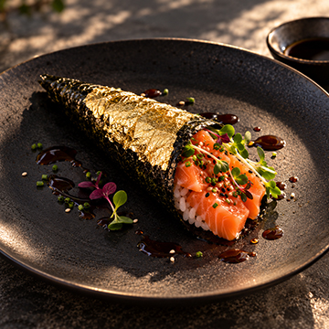 Sushi hand roll wrapped in gold leaf